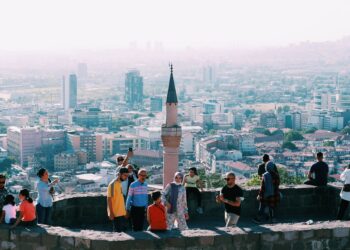 Ankara kalesinden şehri izleyen kalabalık insan grubu ve tarihi minare.