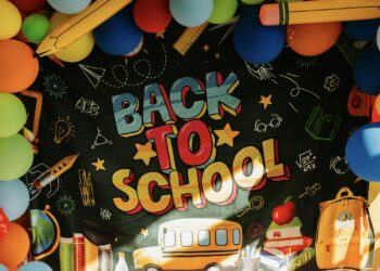 Kara tahta üzerinde 'Back to School' yazısı ve etrafta renkli balonlar.