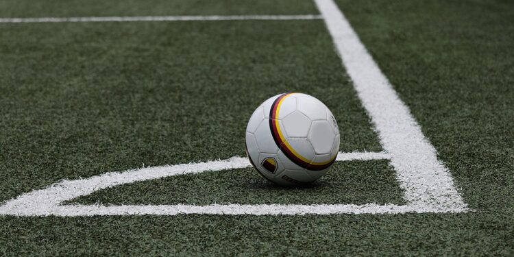 Saha çizgisinin kenarında duran siyah beyaz desenli futbol topu
