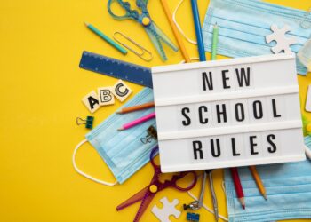 Sarı arka plan üzerinde okul malzemeleri ve New School Rules yazılı pano.