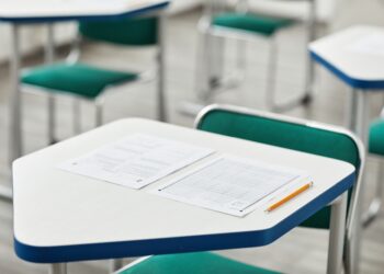 Sınıfta sırada duran sınav kağıtları ve kurşun kalem.