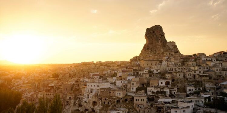 Gün batımında kayalık tepe üzerindeki tarihi yerleşimin genel görünümü.