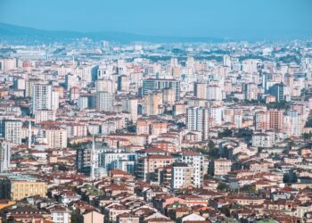 Geniş bir açıdan çekilmiş, yoğun yapılaşmaya sahip şehir ve binalar.