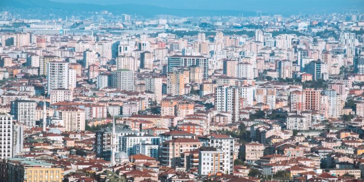 Geniş bir açıdan çekilmiş, yoğun yapılaşmaya sahip şehir ve binalar.